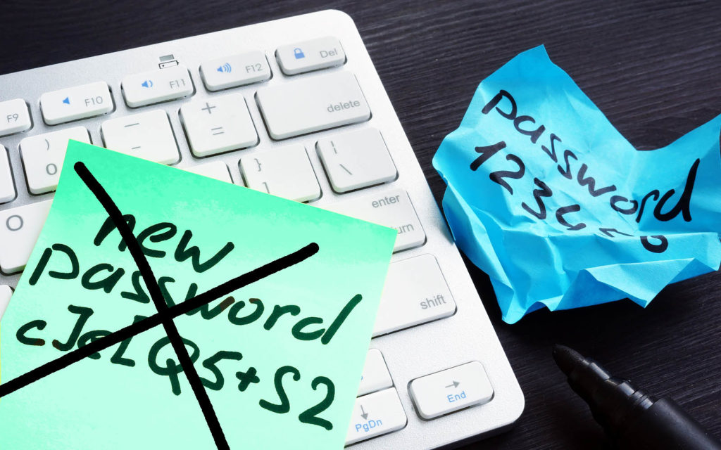 Password policy graphic: A stock image that has poor passwords illustrated on sticky notes alongside a computer keyboard