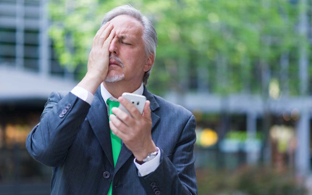 What is vishing example: A stock image of a worried businessman with a hand over his face